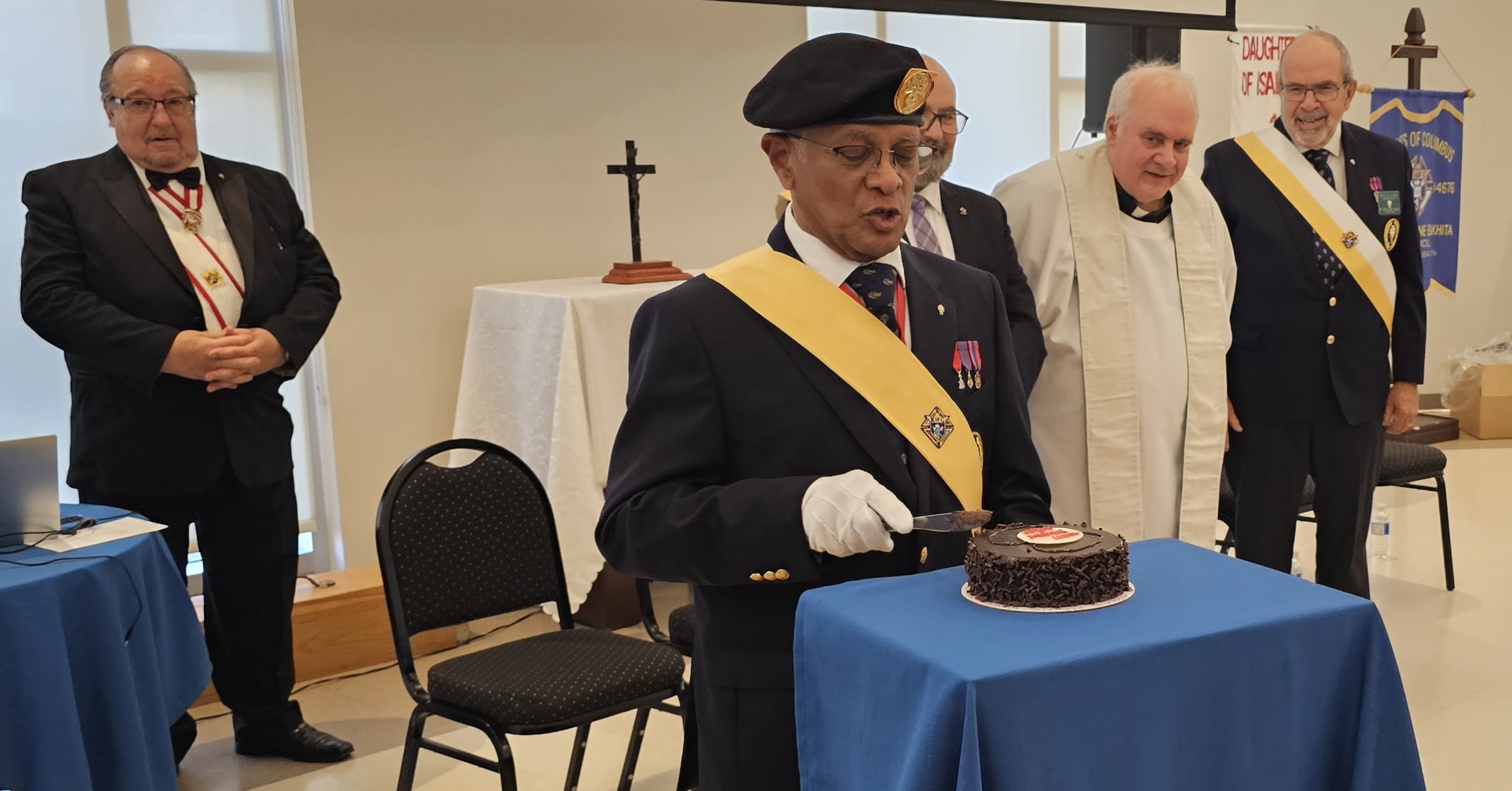 District Master Anthony D'Souza cuts his birthday cake. He eventually gave up trying to cut the cake into 120 slides - one piece for each Sir Knight present during the Fourth Degree Exemplification on November 18, 2023